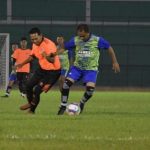 Tampak Bupati Sergai Darma Wijaya (baju hijau) berebut bola dengan pemain lawan dalam pertandingan persahabatan di Stadion Teladan Medan.