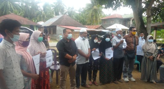 Camat Barumun Selatan Abner Harahap Pejabat didampingi Kepala Desa Gunung Intan Adi Sandra Siregar, S.STP, bersama sejumlah pendamping desa, menyerahkan BLT DD secara simbolis kepada sejumlah penerima, di lokasi Posko Covid-19, desa setempat, Minggu (25/12) siang.