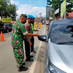 Petugas gabungan Pospam melakukan razia kartu vaksin bagi setiap pengendara yang melintas.