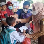 Camat Bintang Bayu Fitrianti (tengah) bersama Ketua APDESI Najarudin menyerahkan potongan tumpeng kepada tokoh masyarakat dan santunan kepada 19 anak yatim dalam puncak Hari Jadi Kecamatan Bintang Bayu ke-15,Senin (3/1/2022).