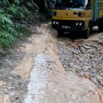 Satu unit truk pengangkut hasil bumi pertanian saat melintasi jalan kabupaten di Luat Doloksordang yang rusaknya parah.