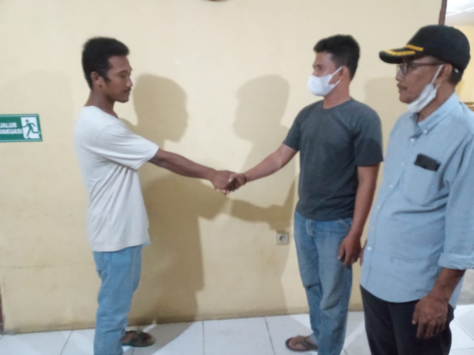 Pemilih kebun singkong yang Ilham (kanan) berjabat tangan dengan Arif sebagai tanda pemberian maaf atas aksi pencurian dua karung singkong pekan lalu.
