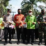 Wabup Sergai Adlin Tambunan, didampingi Camat Kotarih Maningar Manurung (batik hijau) melakukan potong pita tanda peresmian jalan Sialtong, Jum'at (14/1/2022). Photo: AR.Manik/Mitanews.co.id