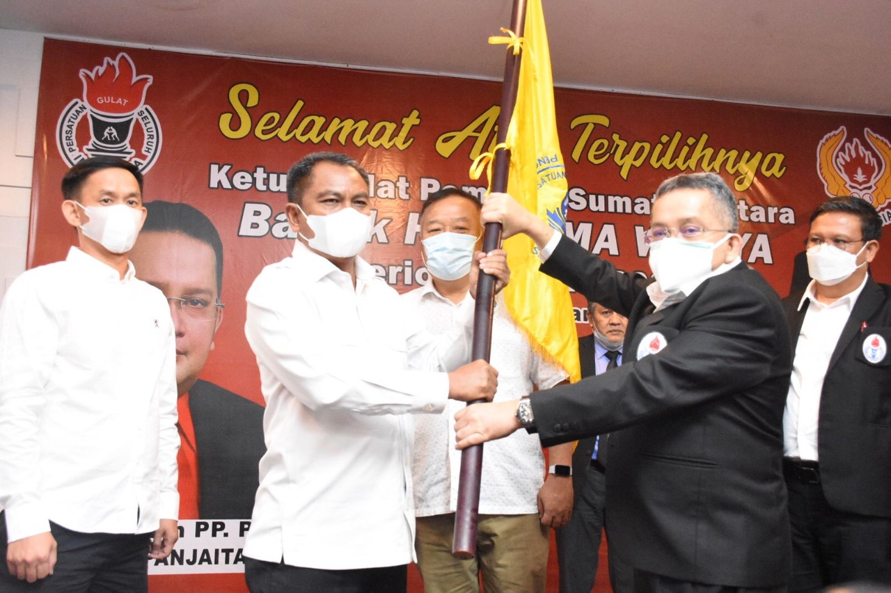 H Darma Wijaya (Bupati Sergai) menerima pataka PGSI yang diserahkan Ketua Pengurus Pusat Trimedya Panjaitan (kanan) usai dikukuhkan sebagai Ketua Umum Pengurus Provinsi (Pengprov) Persatuan PGSI Sumut periode 2022-2026.