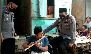 Ket fhoto : Kapolres Madina AKBP H.M. Reza Chairul, A.S, S.I.K, S.H, M.H Di dampingi Kapolsek Siabu, Menyerahkan bantuan kursi roda kepada Nasrin Penyandang disabilitas yang jago main seruling.