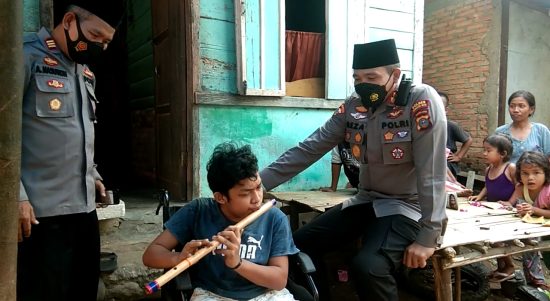 Ket fhoto : Kapolres Madina AKBP H.M. Reza Chairul, A.S, S.I.K, S.H, M.H Di dampingi Kapolsek Siabu, Menyerahkan bantuan kursi roda kepada Nasrin Penyandang disabilitas yang jago main seruling.