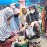 Nek Katinem paling kiri sedang melayani pembeli yang menyerbu dagangannya.(Photo : AR.Manik/Mitanews.co.id ).