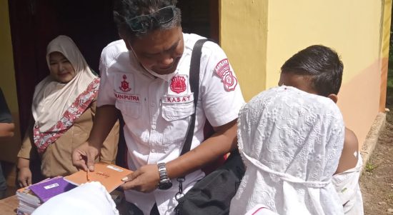 Kasat Reskrim Polres Palas memberikan buku dan pulpen kepada setiap siswa yang divaksinasi