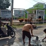 Siswa SMKN I Barumun bergotong royong memperbaiki Jl. Karya Pembangunan yang rusak dengan menempel semen disetiap lubang yang ada dibadan jalan