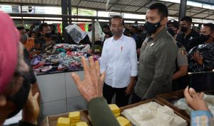 Presiden Republik Indonesia Joko Widodo didampingi Gubernur Sumatera Utara (Sumut) Edy Rahmayadi menyerahkan bantuan modal kepada pedagang di Pasar Kebun Lada Jalan Perintis Kemerdekaan, Kecamatan Binjai Utara, Kota Binjai, Jumat (4/2).