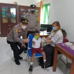 Kapolsek IPTU Domdom Panjaitan (kiri) memberi acungan jempol bersama siswa SD tanda memberikan semangat saat meninjau vaksinasi anak 6-11 tahun di Puskesmas Kotarih, Rabu (9/02/2022).(Foto Ar Manik/ Mitanews.co.id