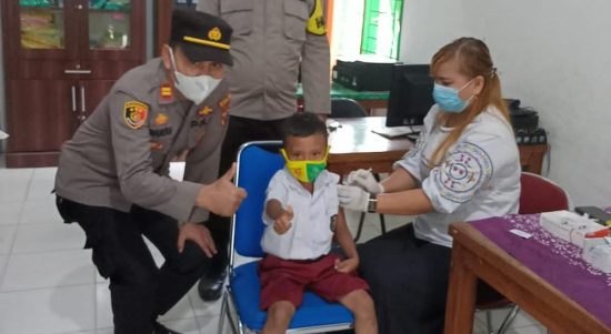 Kapolsek IPTU Domdom Panjaitan (kiri) memberi acungan jempol bersama siswa SD tanda memberikan semangat saat meninjau vaksinasi anak 6-11 tahun di Puskesmas Kotarih, Rabu (9/02/2022).(Foto Ar Manik/ Mitanews.co.id