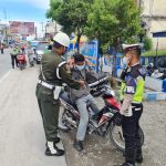 Pihak Satlantas Sergai dan anggota Polisi Militer memberikan masker kepada pengendara yang melintas.