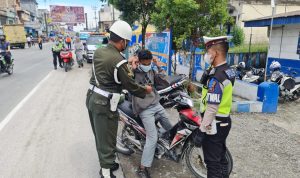 Pihak Satlantas Sergai dan anggota Polisi Militer memberikan masker kepada pengendara yang melintas.