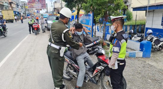 Pihak Satlantas Sergai dan anggota Polisi Militer memberikan masker kepada pengendara yang melintas.