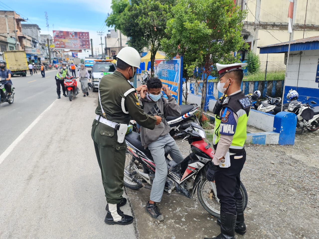 Pihak Satlantas Sergai dan anggota Polisi Militer memberikan masker kepada pengendara yang melintas.