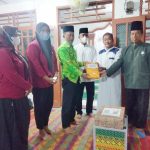 M Kahar Effendi,S.Sos Kepala Badan Kesbangpol (kiri) didampingi Kepala Dinas PMD Sri Rahmayani (dua dari kiri) menyerahkan bingkisan kepada Khairul Ketua BKM Masjid Jami'Al Ikhlas Desa Bah Sidua-dua.