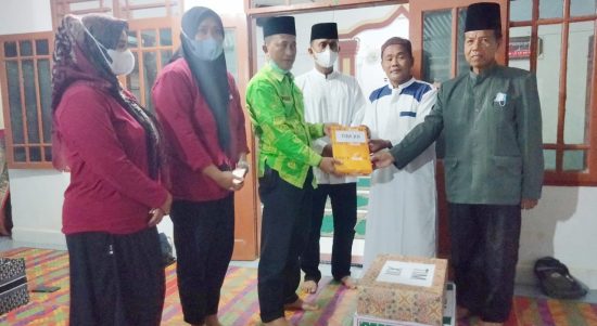 M Kahar Effendi,S.Sos Kepala Badan Kesbangpol (kiri) didampingi Kepala Dinas PMD Sri Rahmayani (dua dari kiri) menyerahkan bingkisan kepada Khairul Ketua BKM Masjid Jami'Al Ikhlas Desa Bah Sidua-dua.