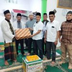 M Kahar Effendi,S.Sos Kepala Badan Kesbangpol (kanan) disaksikan Kades Mainu Tengah dan Camat Dolok Merawan Alpian Purba (nomor dua dan tiga dari kiri) menyerahkan bingkisan kepada Sukiman BKM Masjid Jami' Al Ikhlas Desa Mainu Tengah.