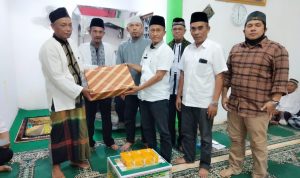 M Kahar Effendi,S.Sos Kepala Badan Kesbangpol (kanan) disaksikan Kades Mainu Tengah dan Camat Dolok Merawan Alpian Purba (nomor dua dan tiga dari kiri) menyerahkan bingkisan kepada Sukiman BKM Masjid Jami' Al Ikhlas Desa Mainu Tengah.