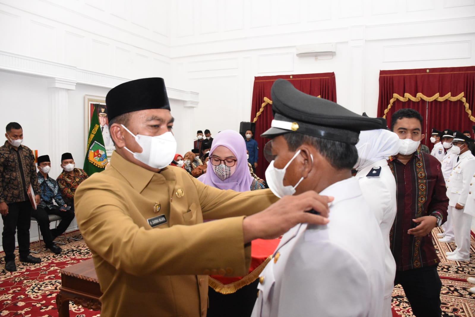 Bupati Sergai Darma Wijaya menyematkan tanda pangkat kepada salah satu Kepala Desa yang dilantik.