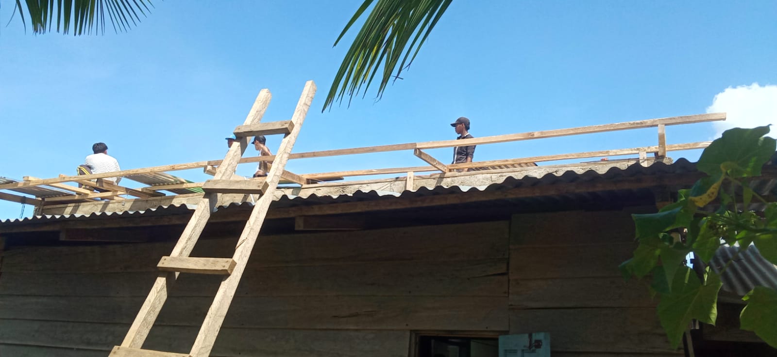 Warga Desa Ujung Batu IV melaksanakan gotong royong untuk perbaikan atap seng bangunan rumah warga yang terkena terjangan angin puting beliung.