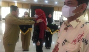 Assisten Pemerintahan Setdaprovsu H. Mhd Fitriyus memperagakan penyematan tanda pangkat penjabat (Pj)