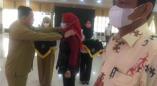 Assisten Pemerintahan Setdaprovsu H. Mhd Fitriyus memperagakan penyematan tanda pangkat penjabat (Pj)