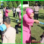 Kapolres Sergai AKBP Ali Machfud berserta istri melakukan prosesi guyuran air bunga pada upacara Korps Raport kepada 27 personil.