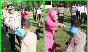 Kapolres Sergai AKBP Ali Machfud berserta istri melakukan prosesi guyuran air bunga pada upacara Korps Raport kepada 27 personil.