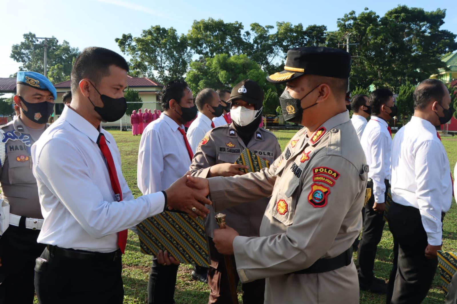 Kapolres Sergai AKBP Ali Machfud (kanan) memberikan reward kepada salah satu personil Unit Reskrim.